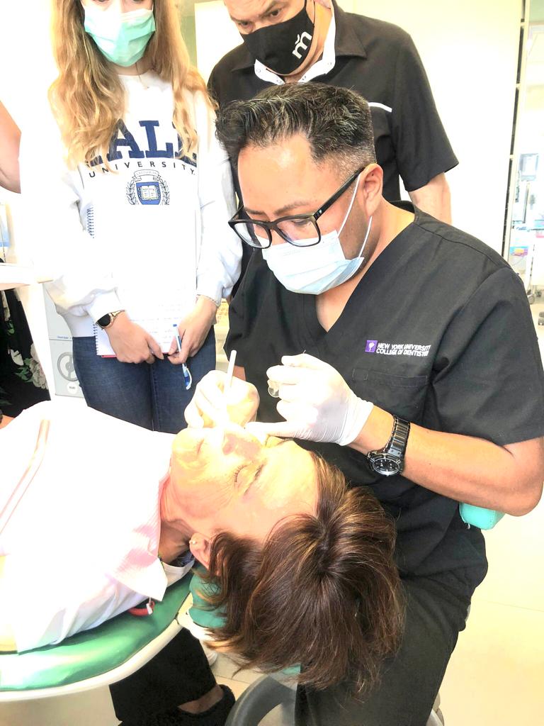 Alumnos practicando técnicas de inyección de ácido hialurónico en un curso del Dr. Edgar Romero