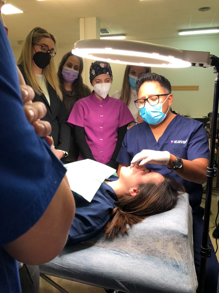 Alumnos practicando técnicas de inyección de ácido hialurónico en un curso del Dr. Edgar Romero